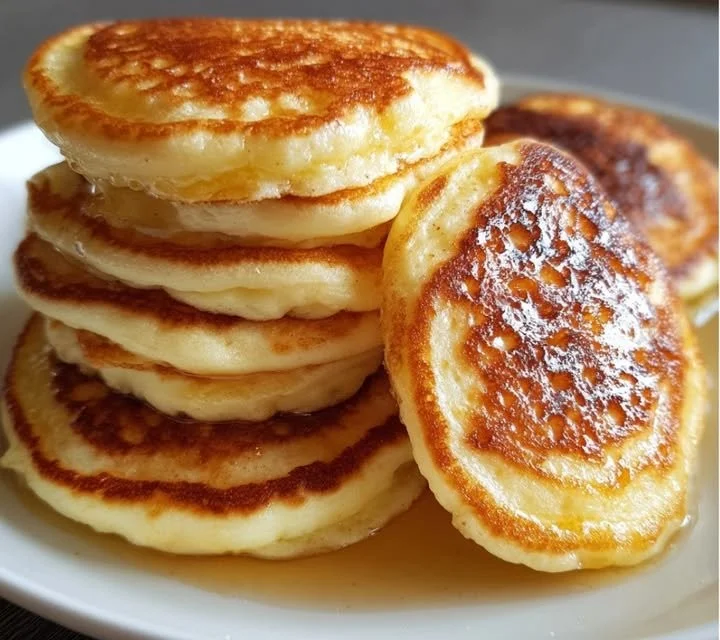 Pancakes moelleux et gonflés sur une assiette avec des fruits frais